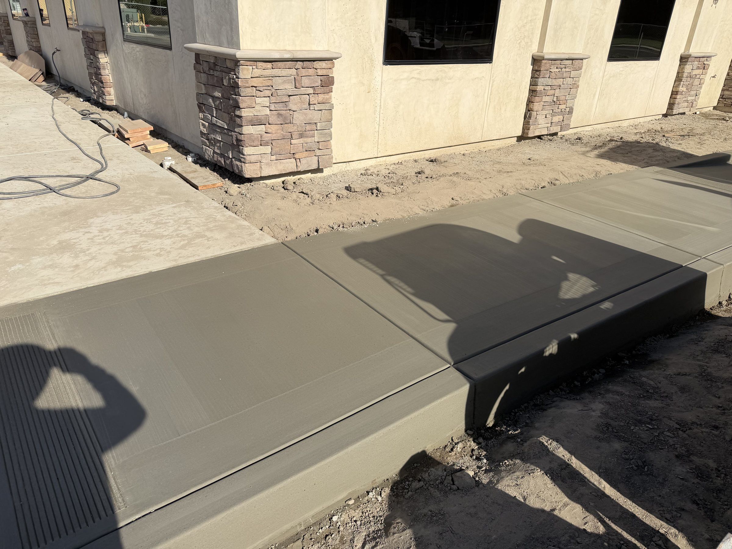 Concrete porch slab along the front of a new stone and stucco house