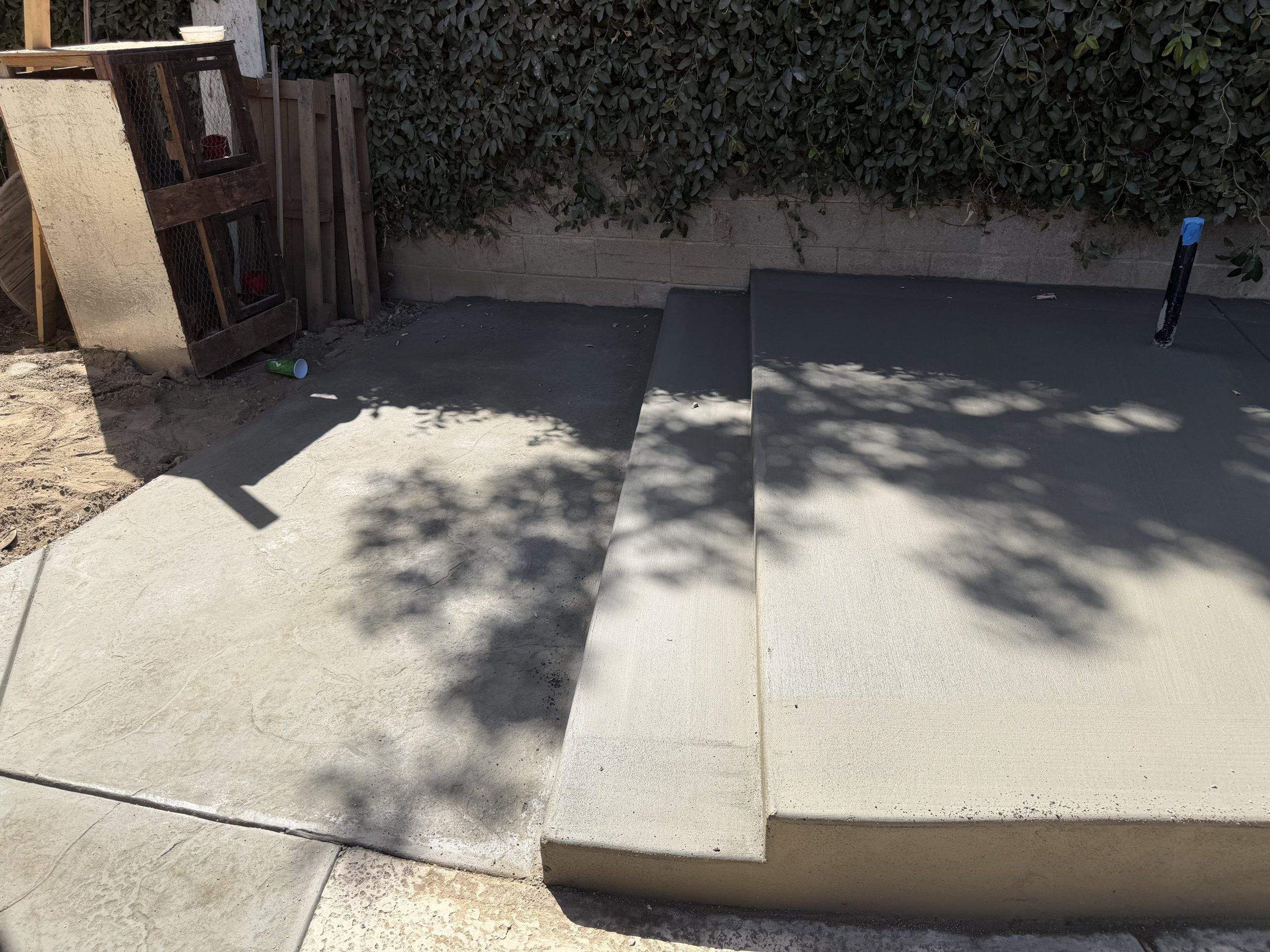 Backyard concrete patio with a wide step up to a second level