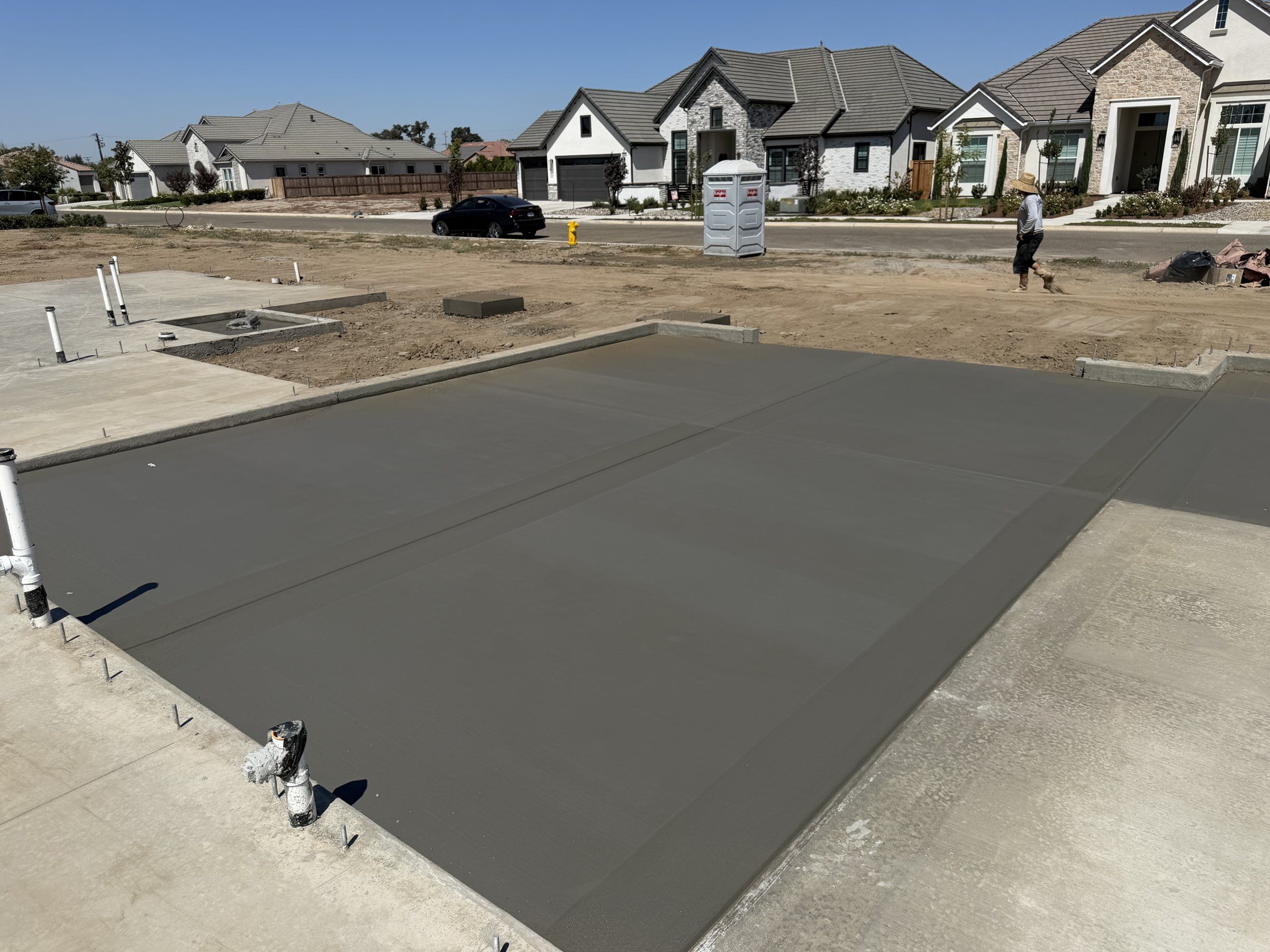 Freshly placed house slab with stub-ups in a subdivision
