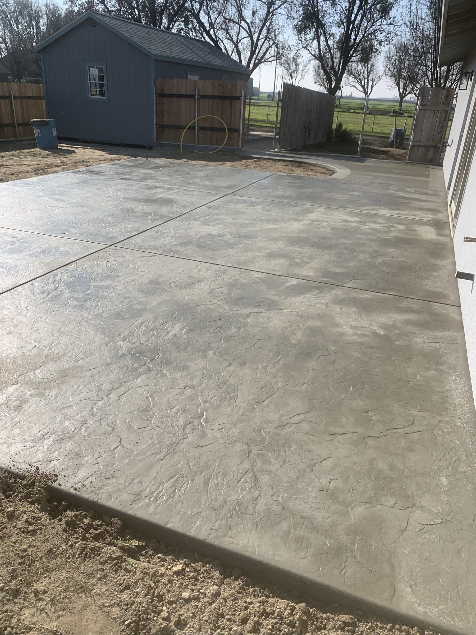 Concrete pad beside a shop building and fence