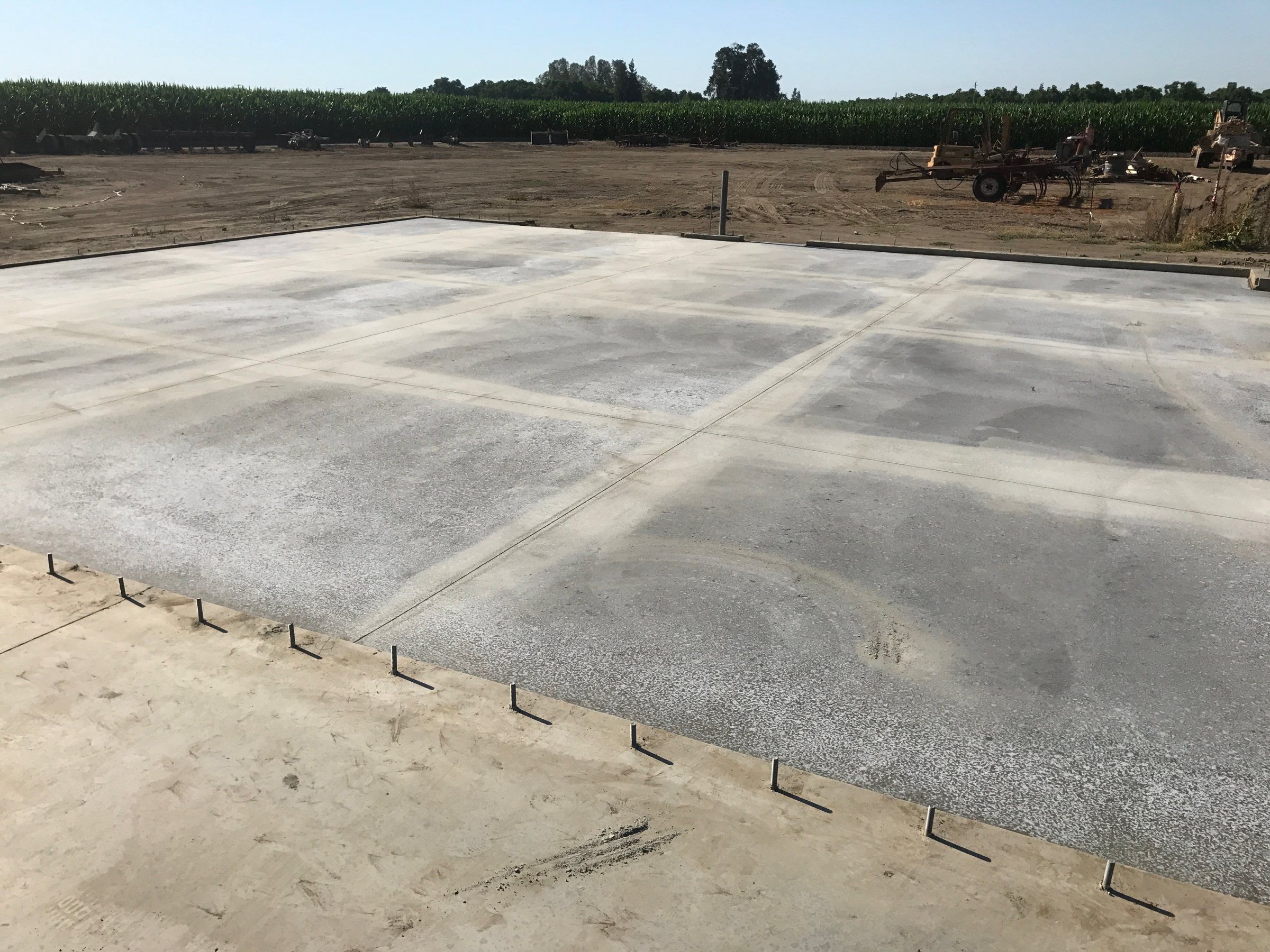 Large concrete slab with a grid of control joints in a rural lot