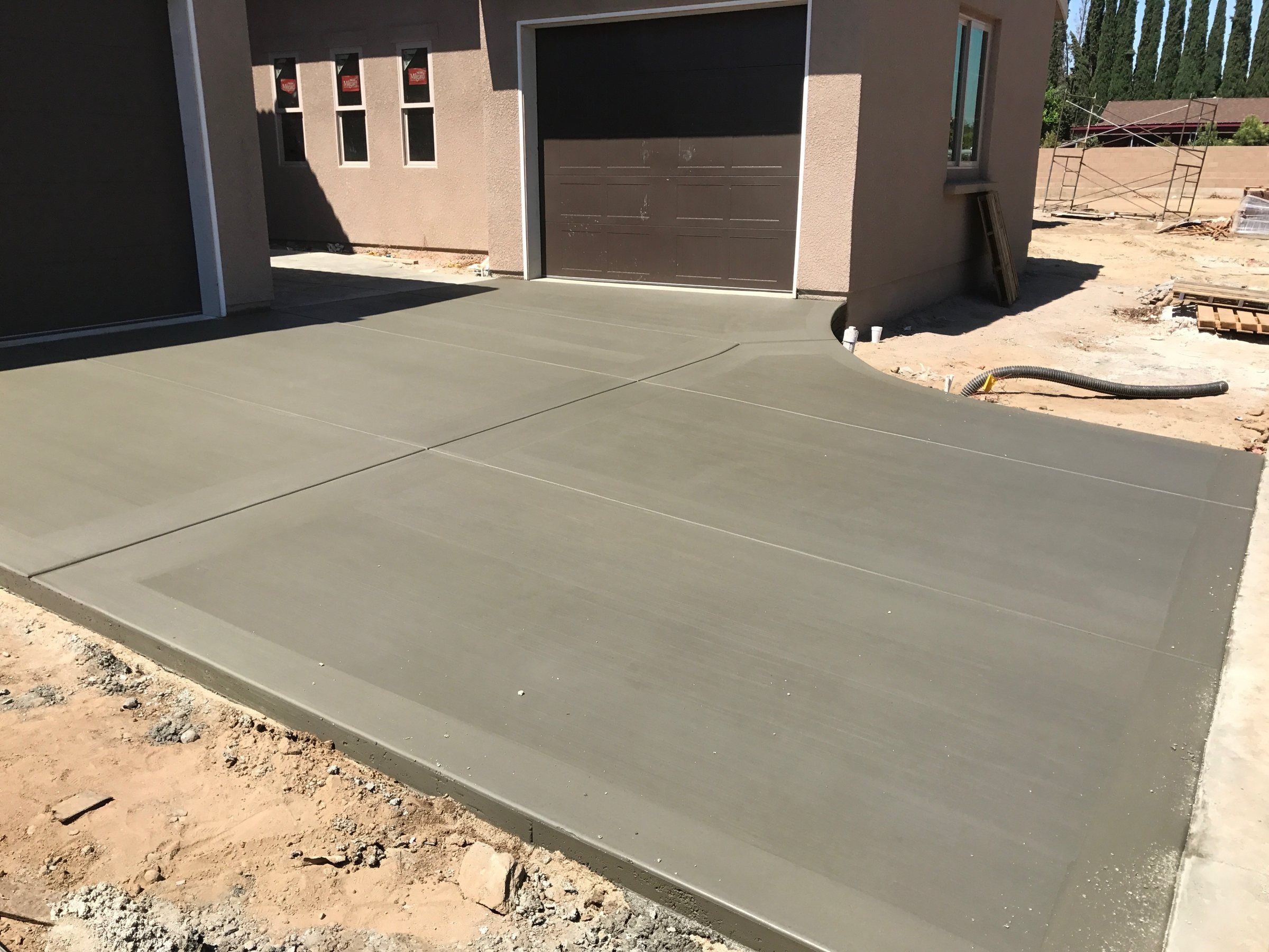 New concrete driveway poured up to a garage door