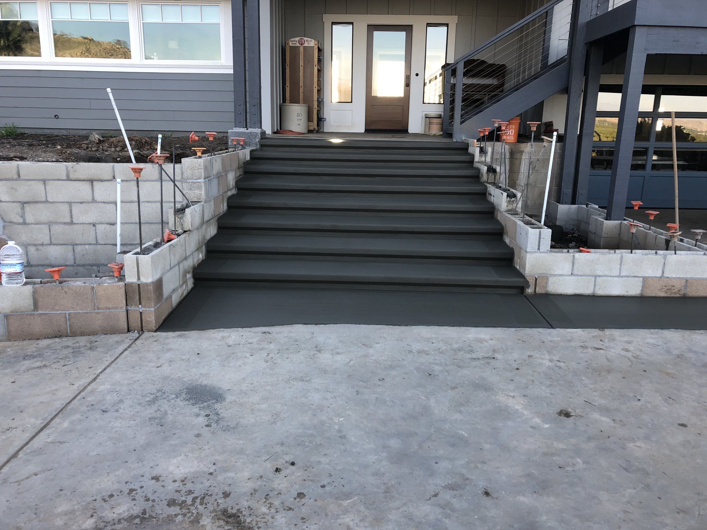 Concrete stairway up to a front porch between block walls