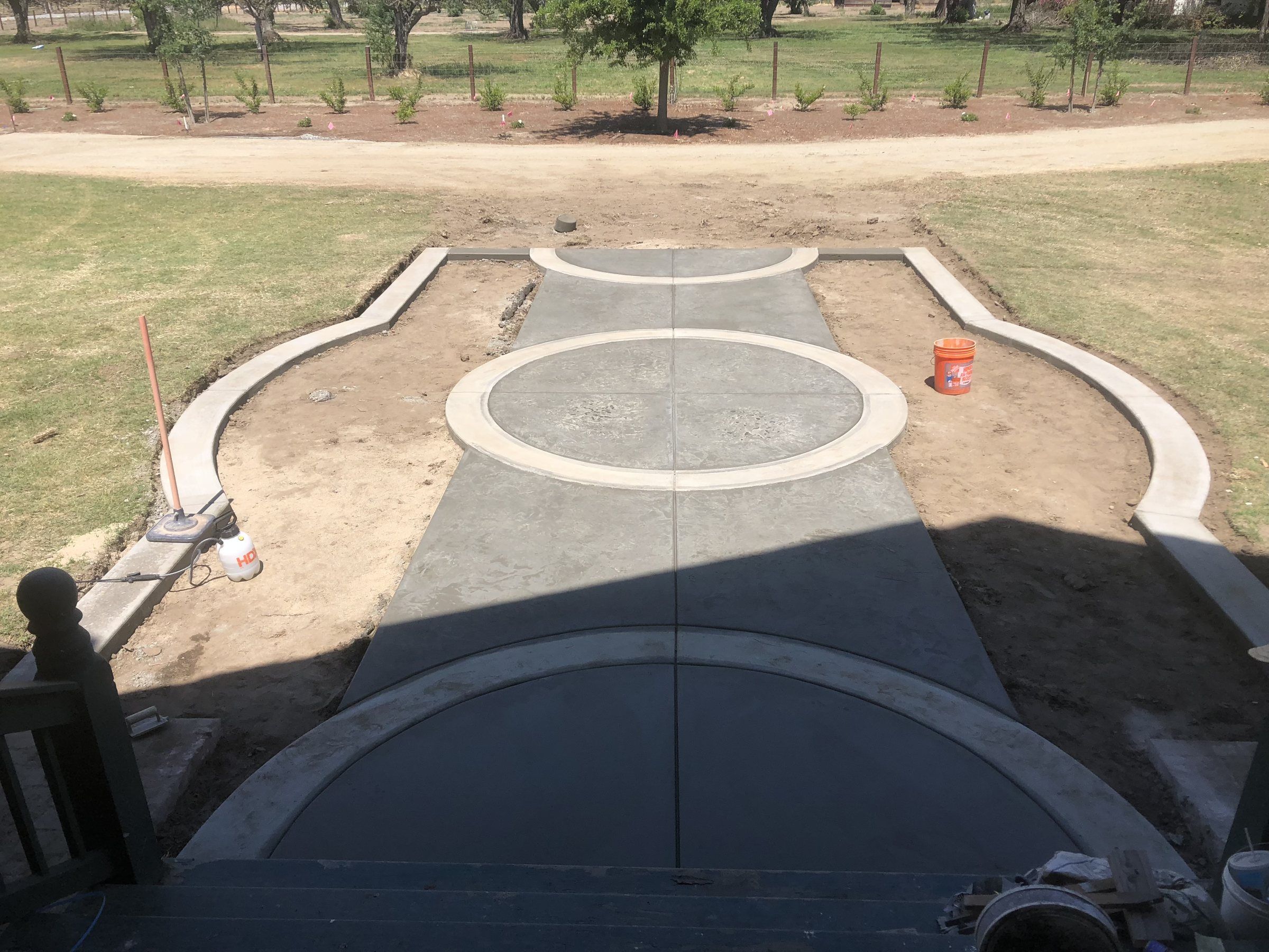 Decorative concrete walkway with stamped circles and curved borders